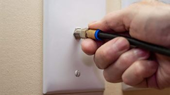 a hand is screwing a light switch on a wall  at Timber Glen Apartments, Batavia